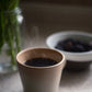 A mug of warm, Bear's French Roast Blend coffee with steam coming off the surface.