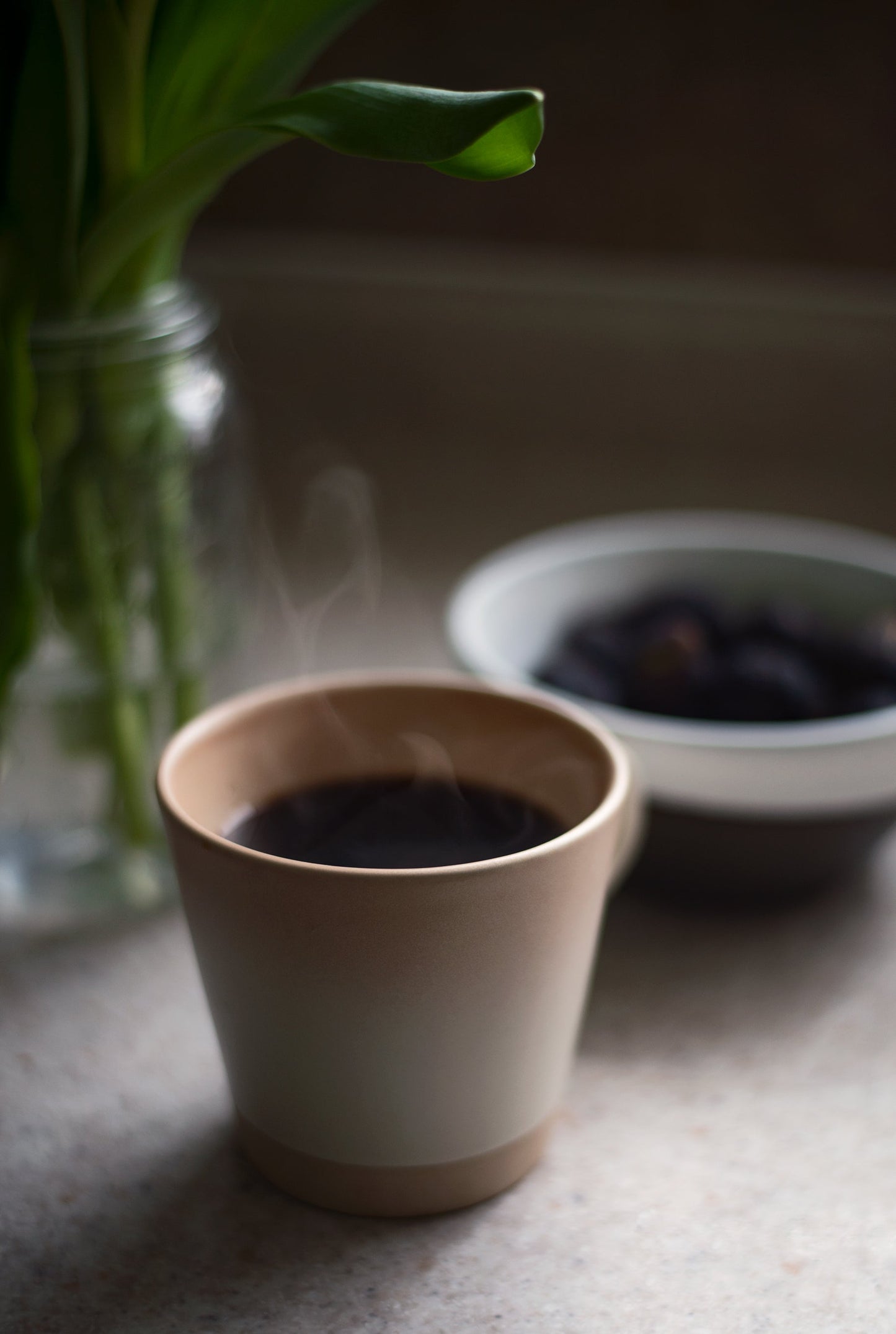 A mug of warm, Bear's French Roast Blend coffee with steam coming off the surface.